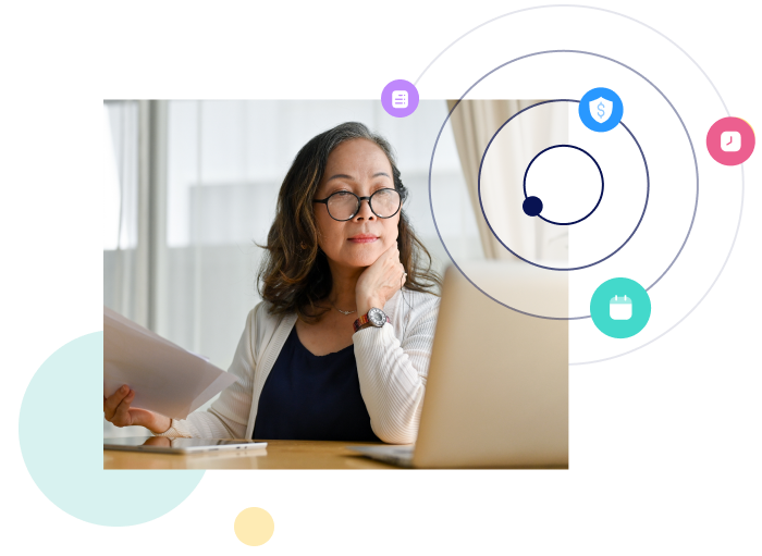 woman looking at her laptop while holding document