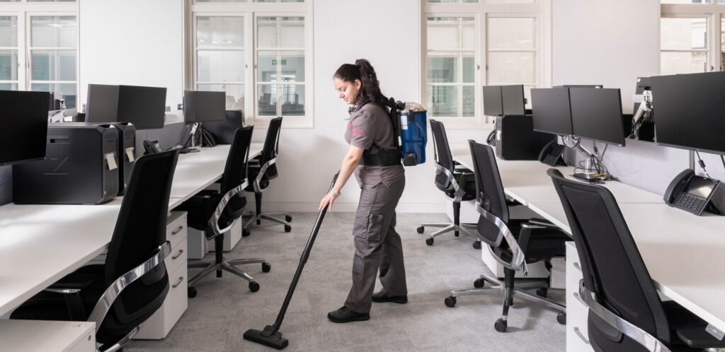 Woman vacuuming the office.